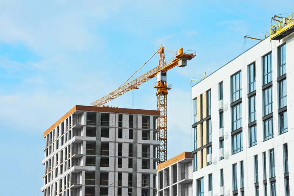 Apartment buildings under construction with crane.
